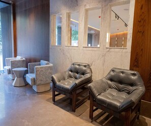 A modern interior with leather armchairs, a marble wall, and a large window. - Executive Room Checkin Amritsar (Amritsar)