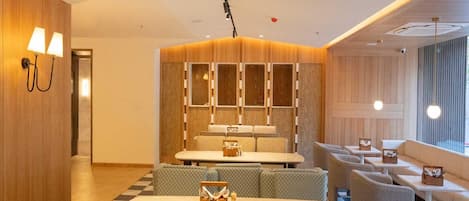 A modern interior with a checkered floor, seating area, and a bar.