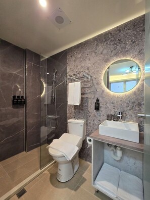 Un baño moderno con ducha de vidrio, inodoro y zona de lavamanos.