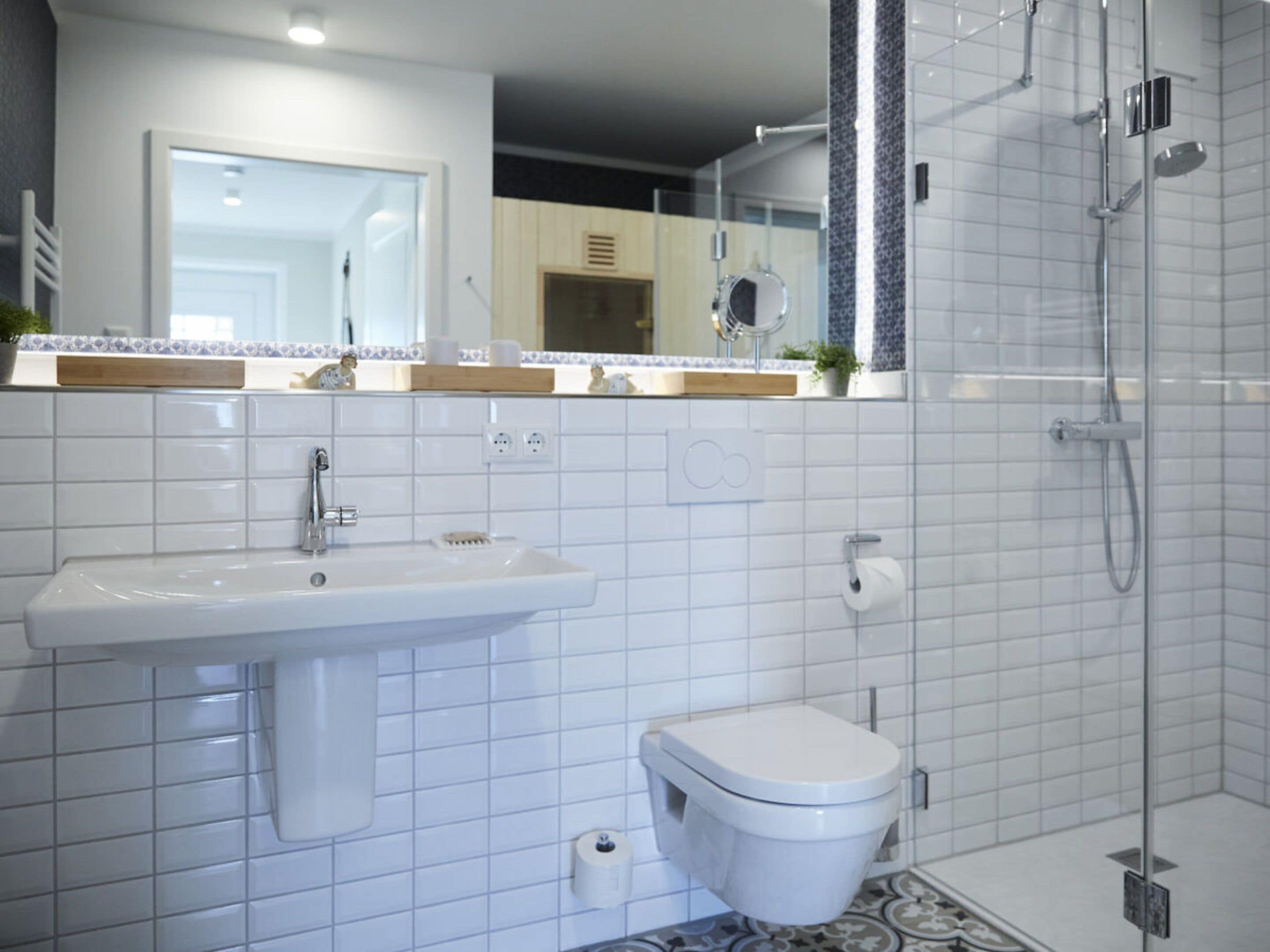 A bathroom with a sink, toilet, and shower.