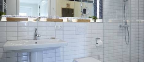 A bathroom with a sink, toilet, and shower.