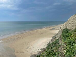 A beach with a rocky cliff and greenery. - Holiday home at Rubjerg Knude Fyr (Løkken)