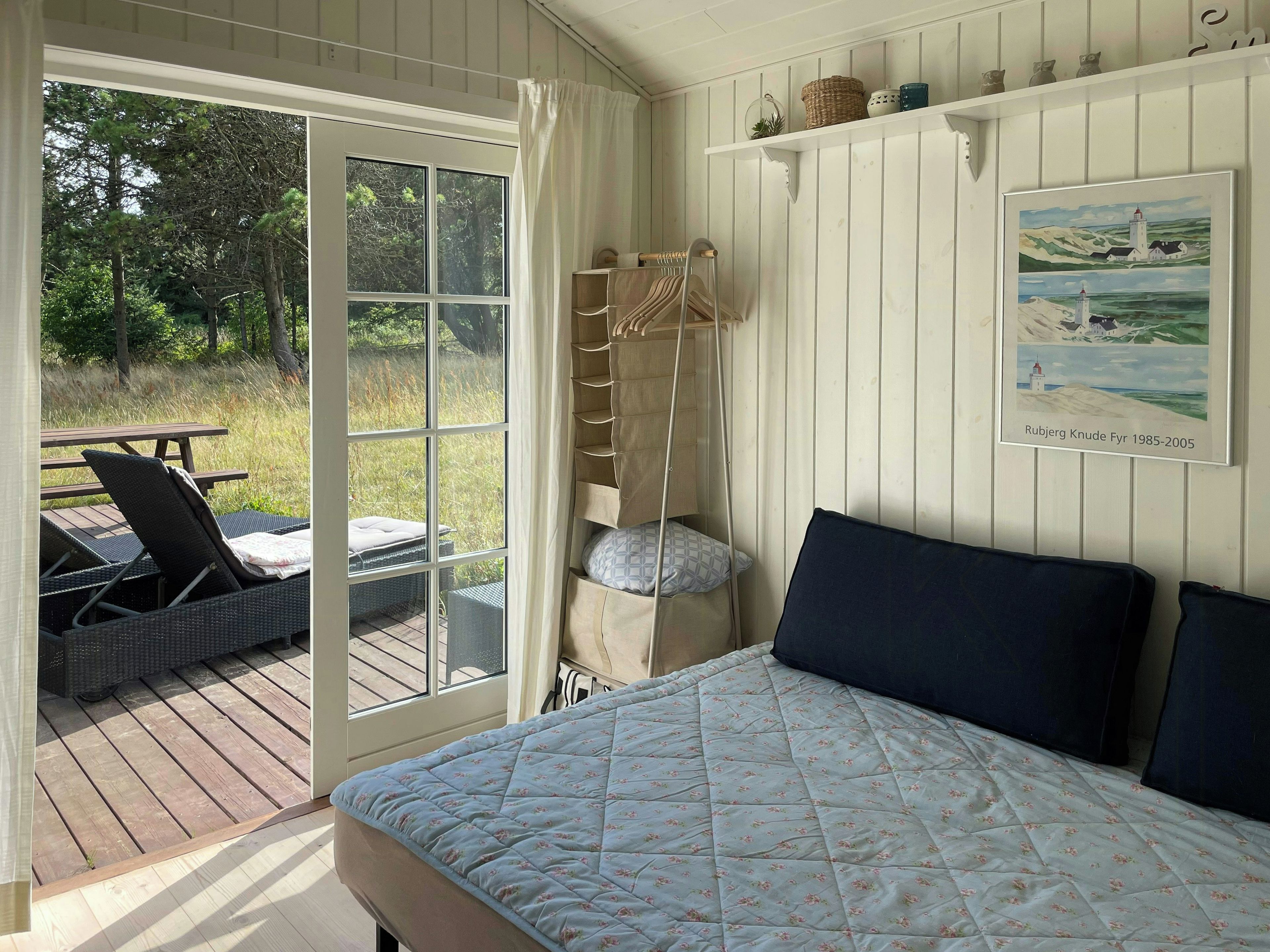 A bedroom with a bed, a hanging chair, and a view of the outdoors.