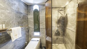 Een moderne badkamer met toilet, hygiëneschuimer en douche.