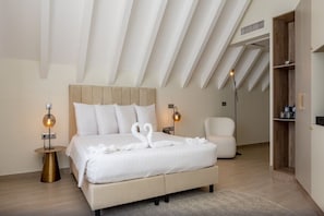 A modern bedroom with a large bed, two bedside lamps, a chair, and a built-in wardrobe. - Harbor Hotel and Casino Curacao (Willemstad)