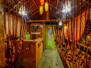 A cozy interior with a reception desk, wooden walls, and hanging decorations. - Butterfly Totem Guesthouse (Puerto Princesa)