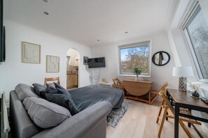 A modern bedroom with a bed, a desk, and a TV. - Top-Floor 1-Bed Apt. in South Kensington (London)