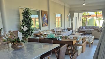 Un comedor amplio con una mesa larga, varias sillas y un centro de mesa con planta decorativa.