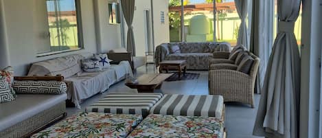 A spacious living area with a sofa set, a coffee table, and a view of the outside.