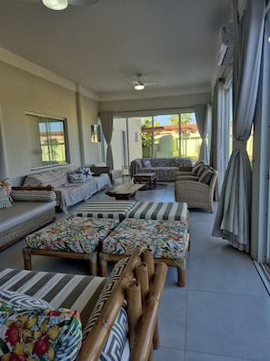 A spacious living area with a sofa set, a coffee table, and a view of the outside.