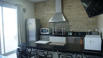 Una cocina moderna con una isla central, electrodomésticos de acero inoxidable y un ventanal grande.