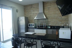 A modern kitchen with a central island, stainless steel appliances, and a large window.