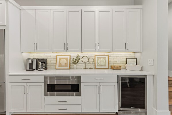 A kitchen with white cabinets, a stainless steel oven, and a microwave.