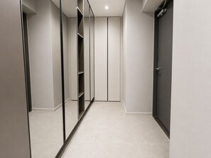 A modern hallway with a mirrored closet, a door, and a tiled floor. - 넓고 쾌적한 프리미엄 숙소! 가족여행 및 장기단기 환영
해운대해변 도보 5분, 해운대전통시장 도보 3분,해운대역 및 버스 정거장 도보 1분 위치 (해운대구)