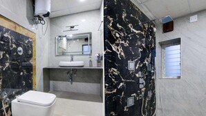 Un baño con inodoro, lavamanos y zona de ducha.