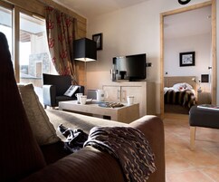 Un salon confortable avec un canapé, une table basse et un téléviseur.