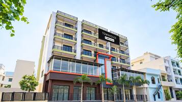 A multi-story building with a sign reading 'TOWNHOUSE' and 'OYO-Serviced'.