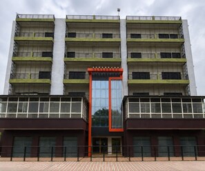 A multi-story building with a central entrance, balconies, and a reflective glass facade. - Deluxe the yug Residency (Varanasi)