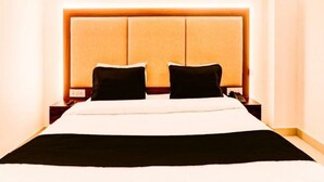 Ein Hotelzimmer mit einem großen Bett, zwei Nachttischen und einem Kopfteil mit Lichtleiste.