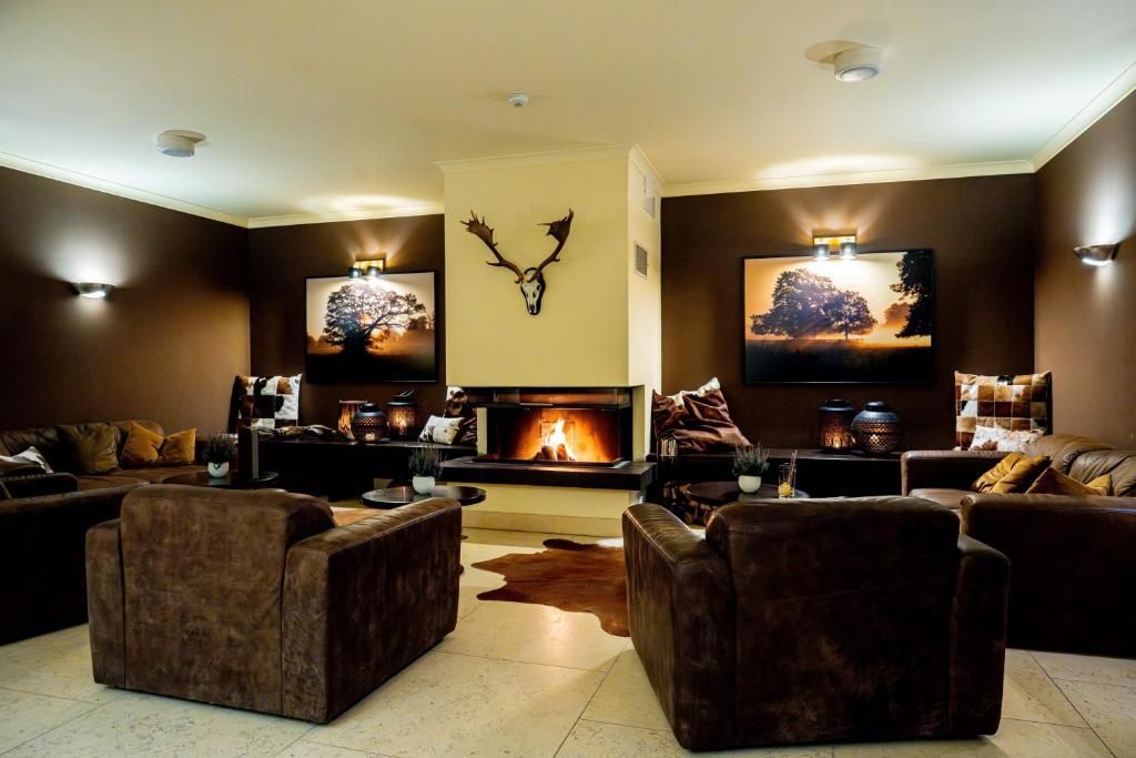 Ein gemütliches Wohnzimmer mit Kamin, Ledersofas und an der Wand befestigter Kunst.
