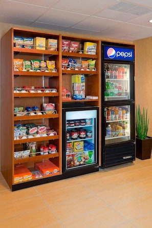 Zona de máquinas expendedoras con aperitivos, bebidas y un refrigerador de Pepsi.