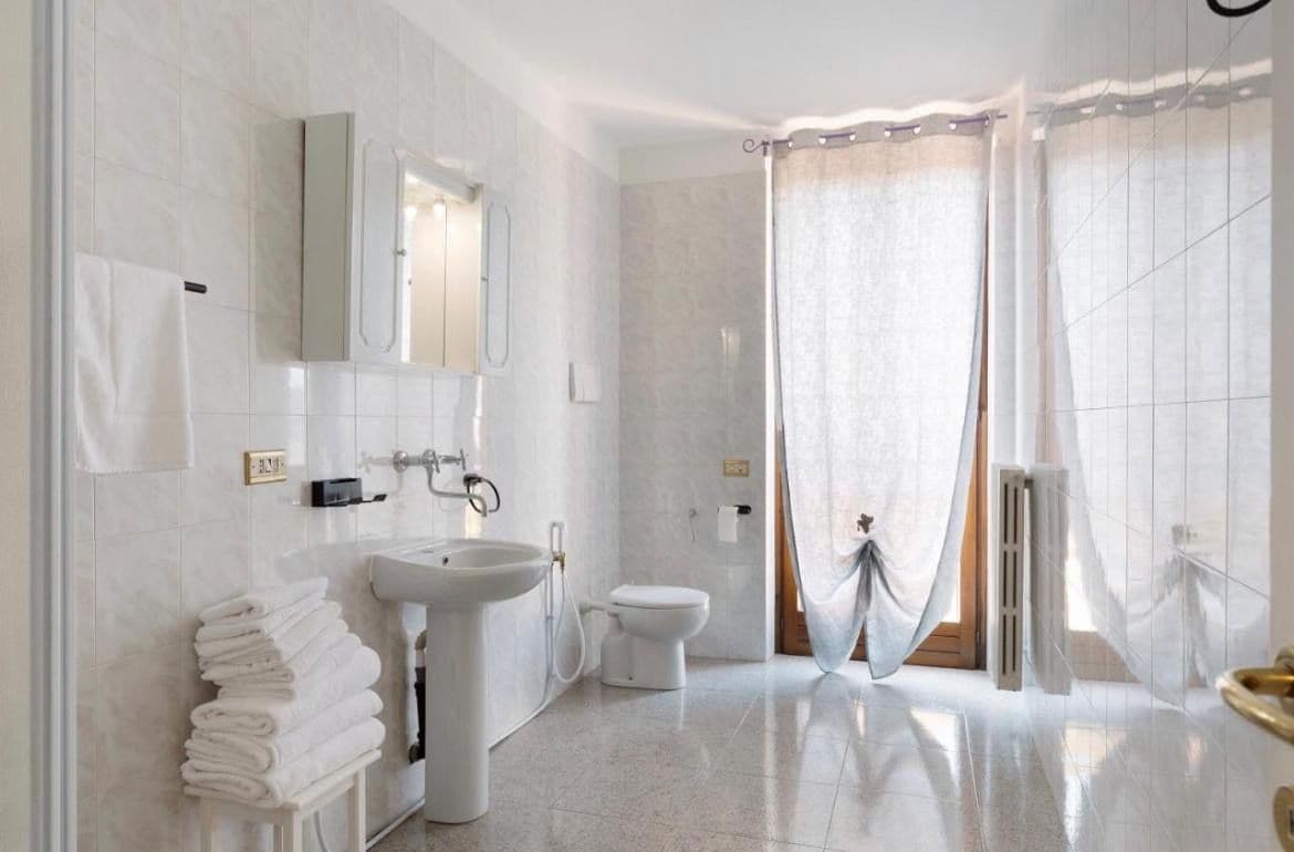 A modern bathroom with a sink, toilet, and shower area.