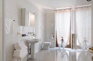 A modern bathroom with a sink, toilet, and shower area. - 4-Rooms house in adorable San Zeno with AC (San Zeno)