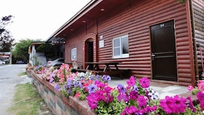 A wooden cabin with a picnic table and a sign that reads 'Come Inn.' - Come Inn (Hengchun)