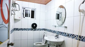 A bathroom with a toilet, sink, and shower. - Come Inn (Hengchun)