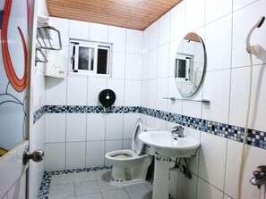 A bathroom with a toilet, sink, and shower. - Come Inn (Hengchun)