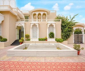 A building with a central courtyard, a staircase leading to the entrance, and a gated entrance. - Family Rooms With Twin King bed Amar Resorrt (Motihari)