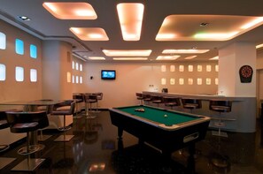 A billiards room with a pool table, bar area, and seating. - Keys Hotel (Thiruvananthapuram)