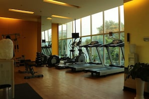 A gym with treadmills, stationary bikes, and weight machines. - Keys Hotel (Thiruvananthapuram)