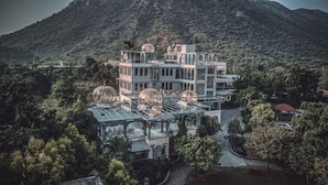 Um edifício com vários andares, terraço envidraçado e várias gaiolas de pássaros.