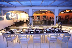 A dining area with a long table set for multiple guests, surrounded by ornate chairs. - The Royal Retreat (Udaipur)