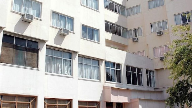 Een hotel met meerdere verdiepingen, een zwembad, terras en airconditioningsinstallaties.