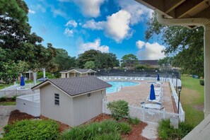 A backyard with a swimming pool, a small shed, and a fenced area with lounge chairs. - 3 Bedroom- Seascape Golf and Beach Resort (Miramar Beach)