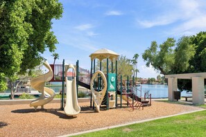 Ein Spielplatz mit Rutsche, Klettergerüsten und einem Pavillon.