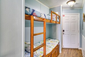 A bunk bed room with a door and a light fixture. - Cozy condo with beautiful ocean views (Corpus Christi)