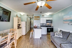 A compact kitchen with a microwave, stove, and wooden cabinets. - Cozy condo with beautiful ocean views (Corpus Christi)