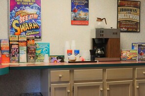 Eine Theke mit verschiedenen Filmplakaten, Werbematerialien, einer Kaffeemaschine und einer Mikrowelle.