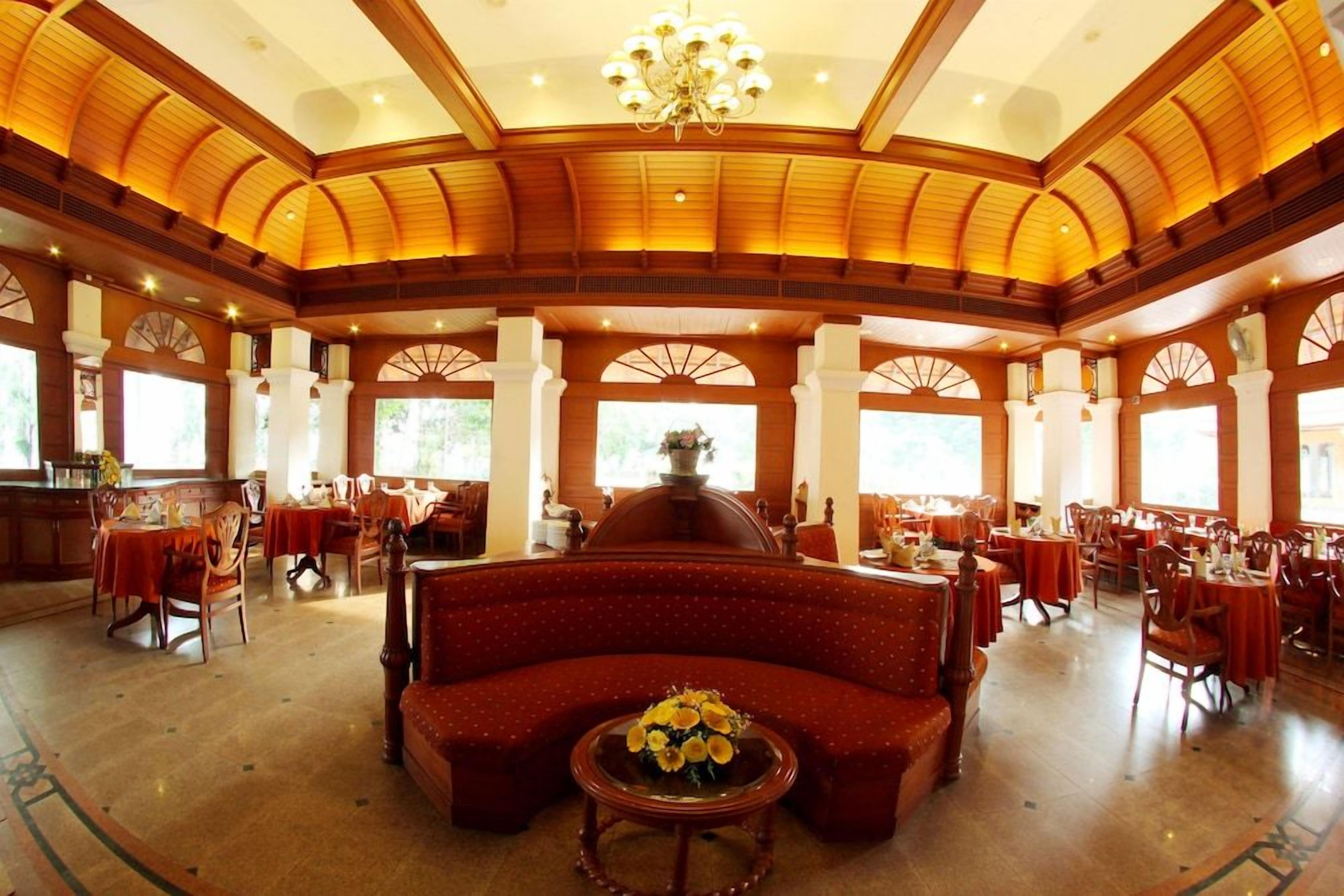 A spacious lobby with a high ceiling, wooden beams, and a central seating area.