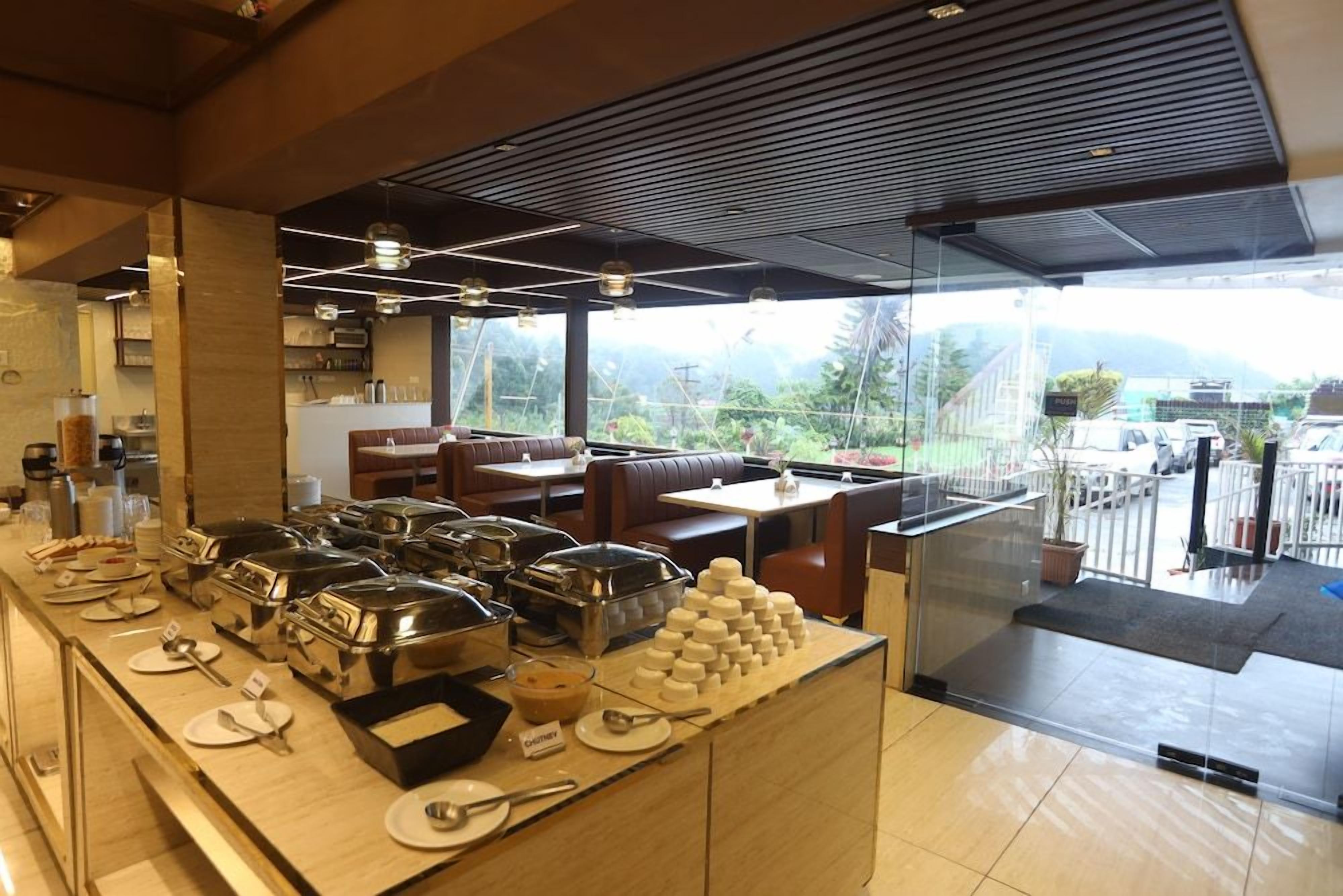 A buffet area with various food stations, seating arrangements, and a view of the outdoors.