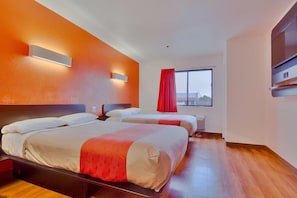 Habitación de hotel con dos camas, un ventanal grande y una cortina roja.