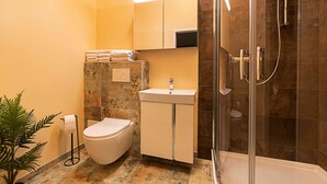 A bathroom with a toilet, sink, and shower. - Fabric-Apartments (Dettingen an der Erms)