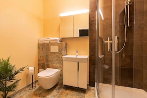A bathroom with a toilet, sink, and shower. - Fabric-Apartments (Dettingen an der Erms)