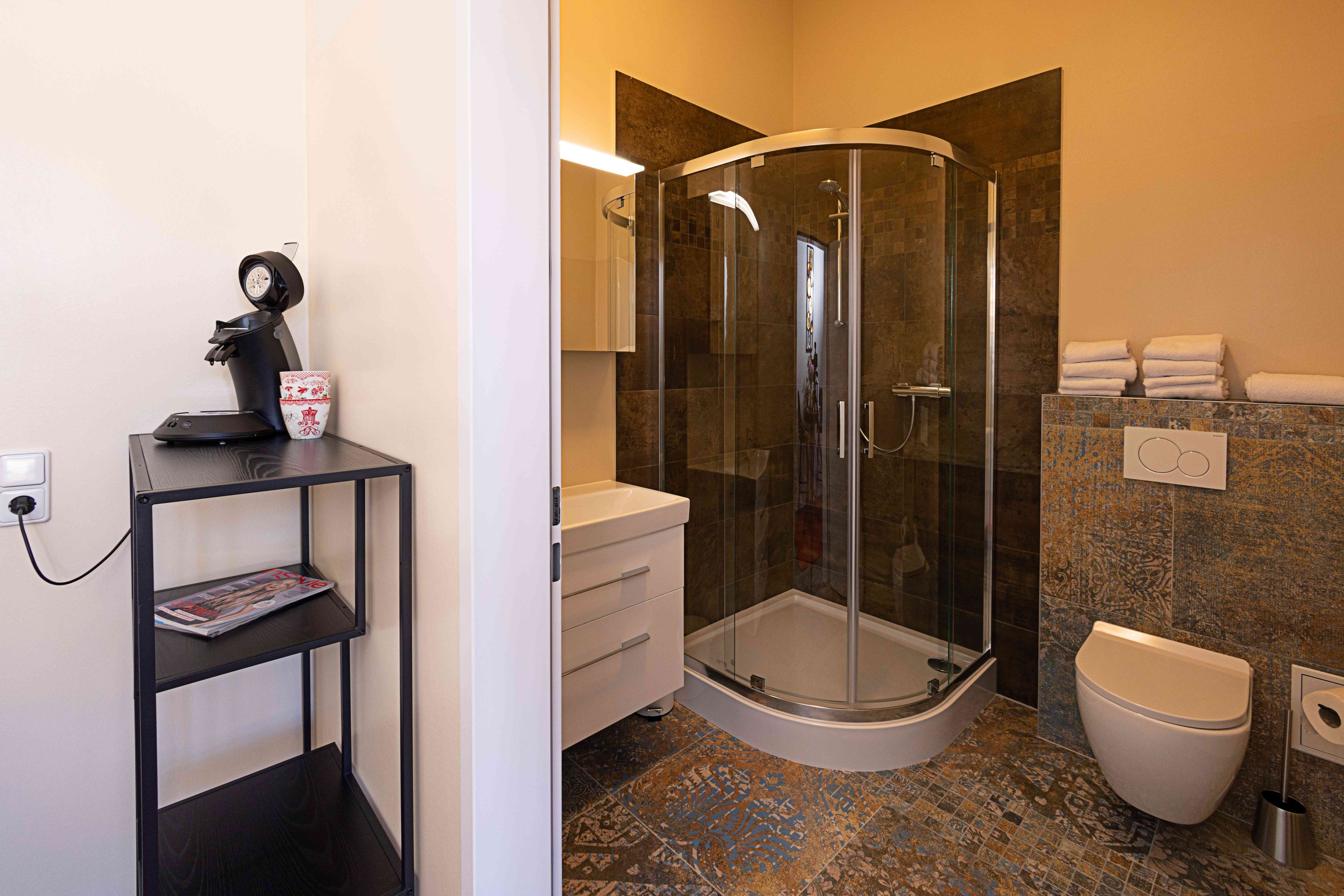 A modern bathroom with a glass-enclosed shower, a toilet, and a sink.