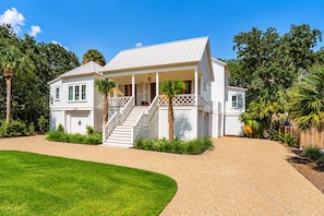 A two-story house with a covered porch and a staircase leading to the entrance. - Beach Escape, close to beach, new custom home (Isle Of Palms)