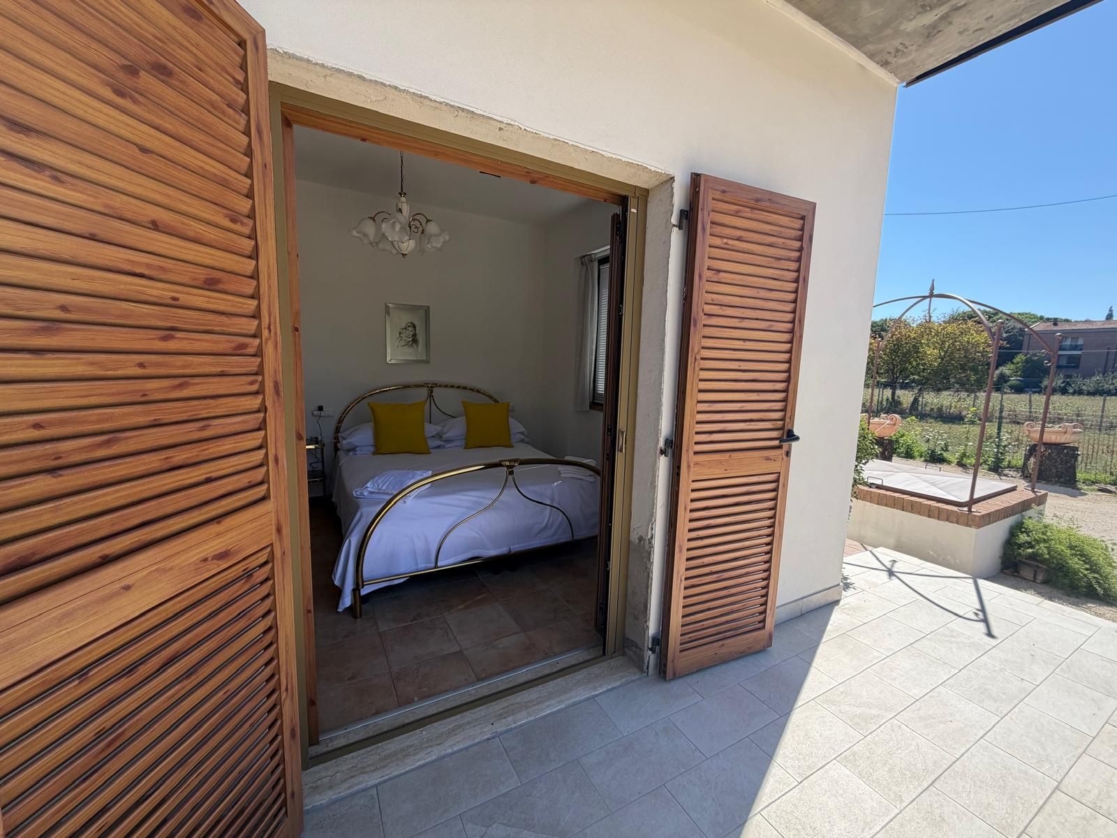 Un dormitorio con cama, mesita de noche y ventana.