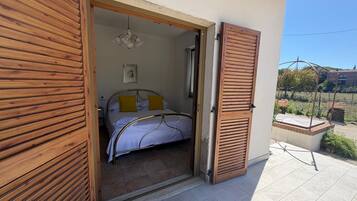 Un dormitorio con cama, mesita de noche y ventana.